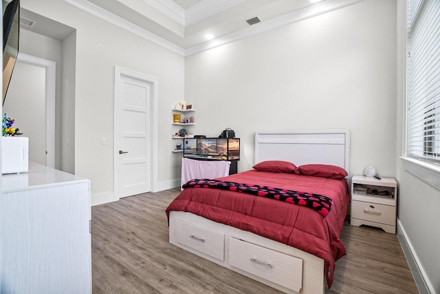 bedroom with crown molding and hardwood / wood-style flooring