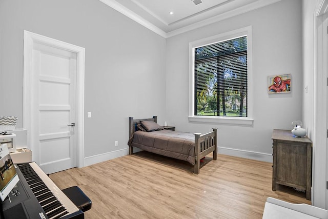 bedroom with ornamental molding and light hardwood / wood-style floors