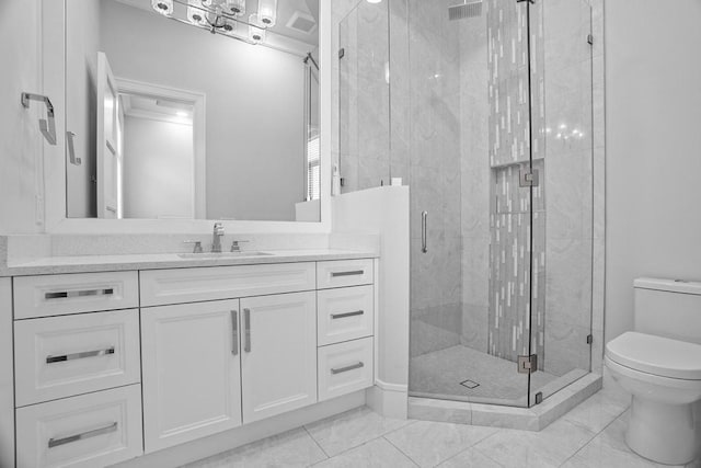 bathroom featuring vanity, a shower with shower door, and toilet