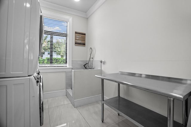 laundry area with stacked washer and dryer, crown molding, and light tile patterned flooring