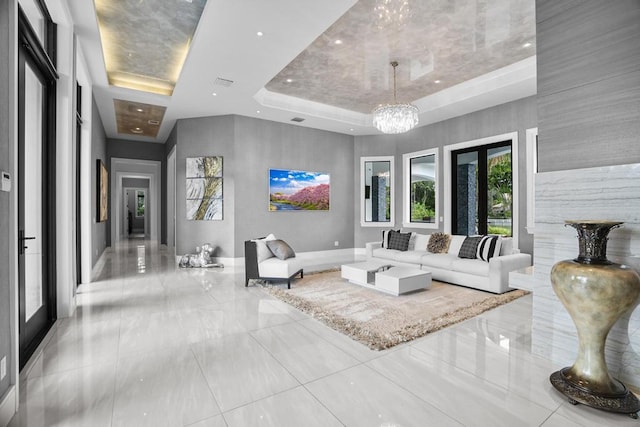 living room with a notable chandelier and a raised ceiling