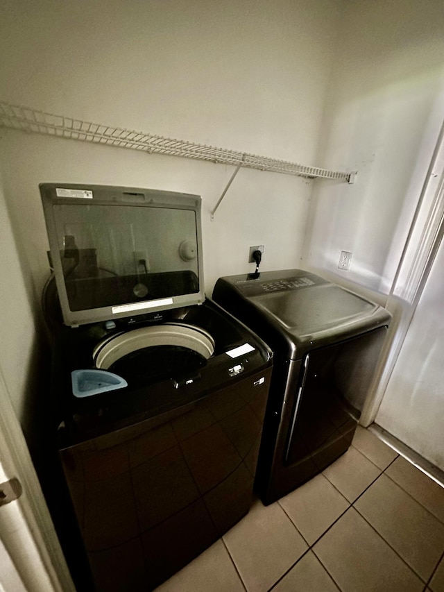 laundry area with light tile patterned floors and washer and dryer