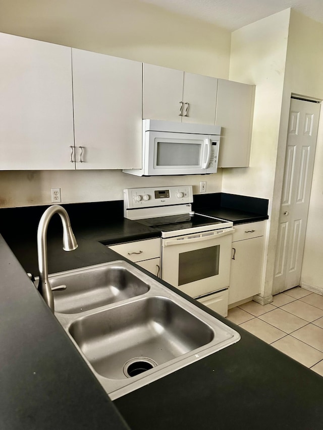 kitchen featuring sink, white appliances, white cabinets, and light tile patterned flooring