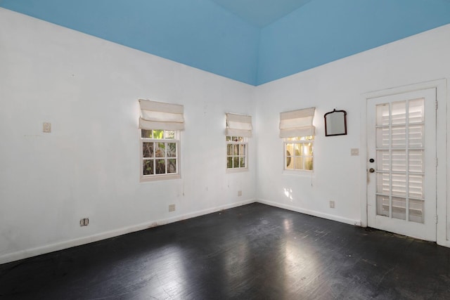 empty room with dark wood finished floors and baseboards