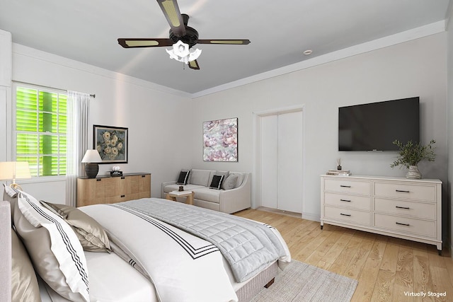 bedroom featuring a ceiling fan, light wood-style flooring, and crown molding