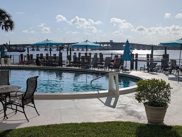 view of pool featuring a patio and a water view