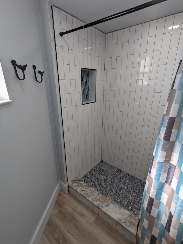 bathroom with walk in shower and hardwood / wood-style flooring