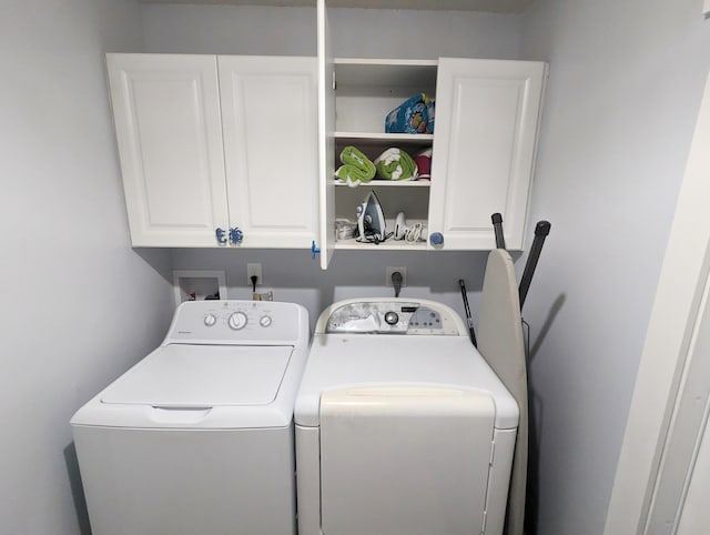 clothes washing area featuring cabinets and independent washer and dryer