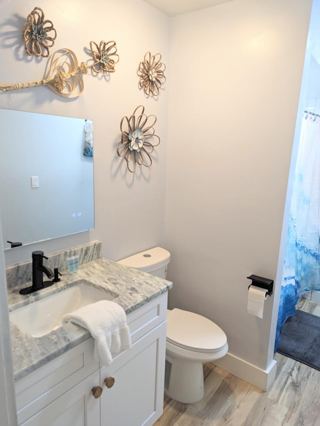 bathroom with vanity, hardwood / wood-style flooring, and toilet