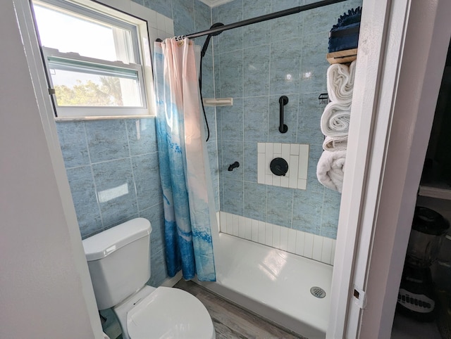 bathroom with toilet, a shower with shower curtain, and tile walls