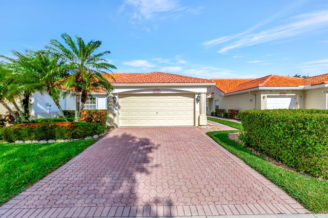 view of front of house with a tiled roof, decorative driveway, a garage, and stucco siding