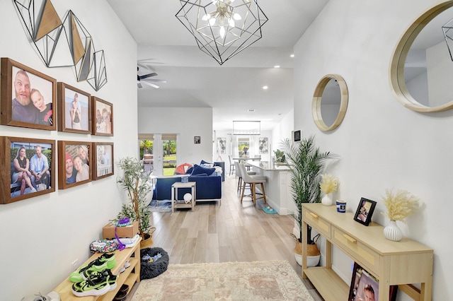 hall with a notable chandelier, light hardwood / wood-style flooring, and french doors