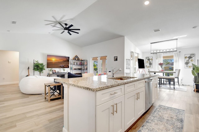 kitchen with sink, white cabinetry, light stone countertops, an island with sink, and stainless steel dishwasher