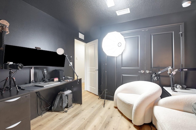 office area featuring light hardwood / wood-style floors and a textured ceiling