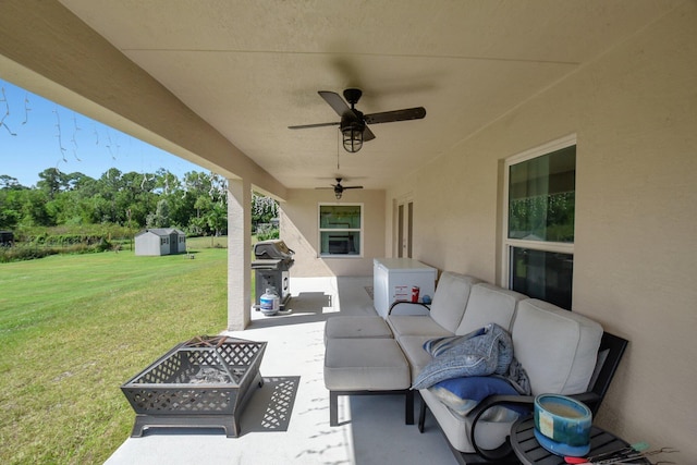 view of patio / terrace with ceiling fan, an outdoor living space with a fire pit, grilling area, and a storage shed