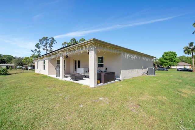 rear view of property featuring central AC unit, a fire pit, a patio area, and a yard