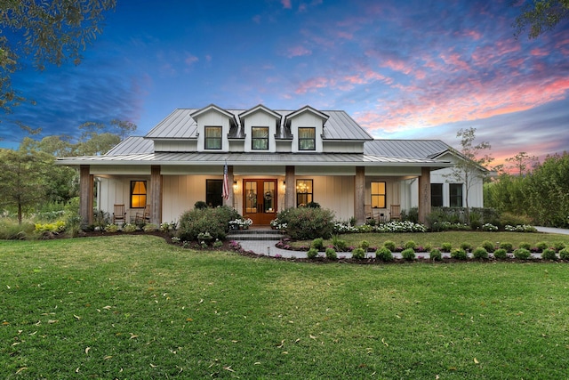 modern inspired farmhouse featuring french doors, a porch, and a yard