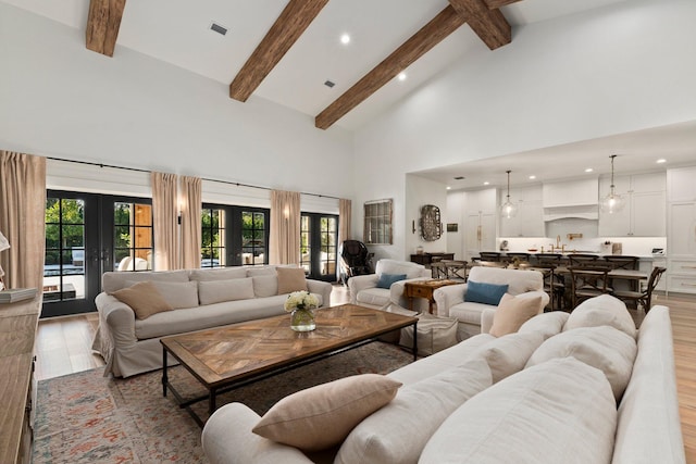 living room with light hardwood / wood-style flooring, high vaulted ceiling, and french doors