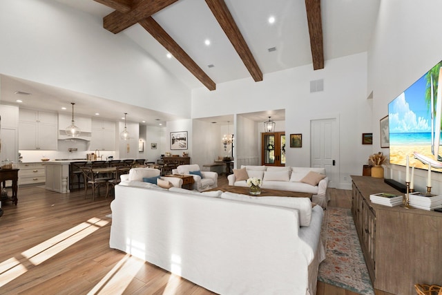 living room featuring high vaulted ceiling, beam ceiling, and light hardwood / wood-style floors