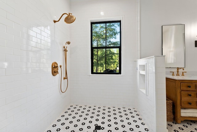 bathroom featuring a tile shower and vanity