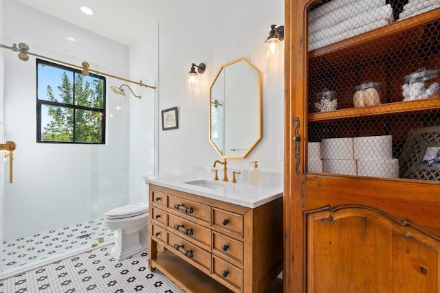 bathroom featuring tile patterned flooring, vanity, tiled shower, and toilet