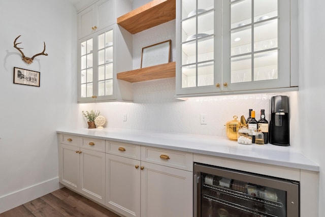 bar featuring tasteful backsplash, dark hardwood / wood-style floors, beverage cooler, and white cabinets