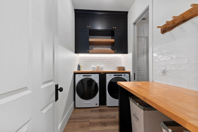 laundry room featuring cabinets, dark hardwood / wood-style floors, and washer and dryer