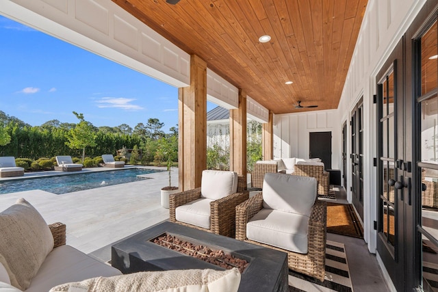 view of patio / terrace with an outdoor living space with a fire pit and french doors