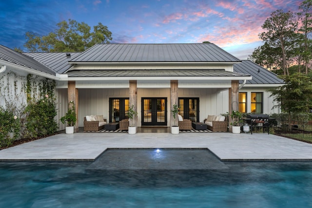 back house at dusk with french doors, an outdoor hangout area, and a patio area