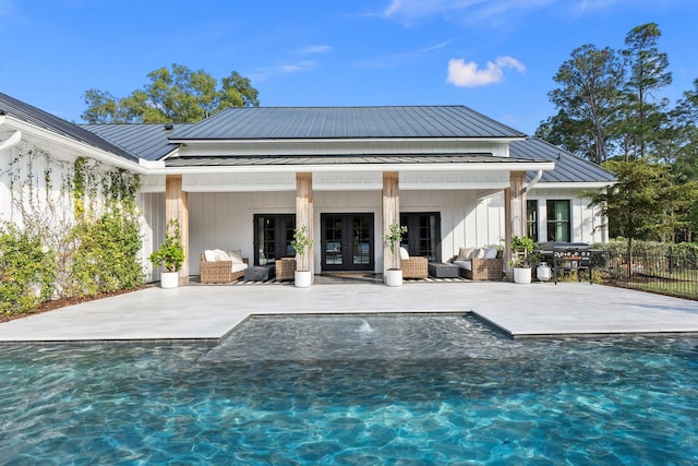 rear view of house with french doors, outdoor lounge area, a fenced in pool, and a patio area