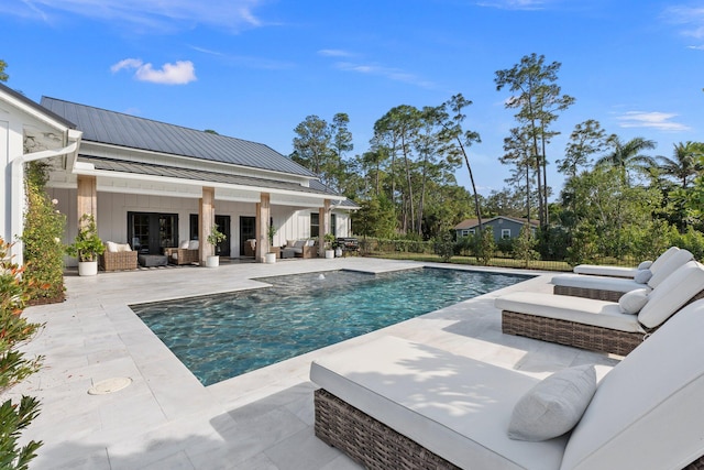 view of pool featuring an outdoor living space, an outbuilding, and a patio area