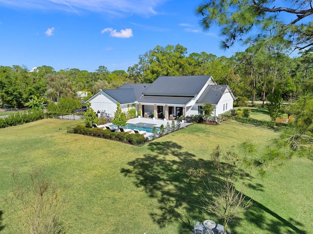 back of property with covered porch, a patio area, and a lawn