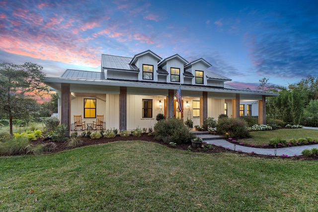 view of front of property featuring covered porch and a lawn