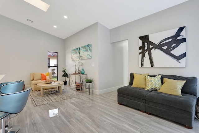 living room featuring lofted ceiling with skylight