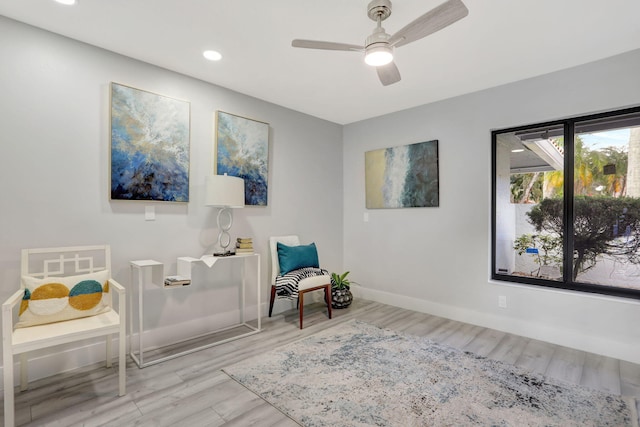 living area with ceiling fan and light hardwood / wood-style floors