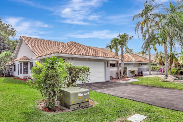 mediterranean / spanish home featuring a garage and a front yard