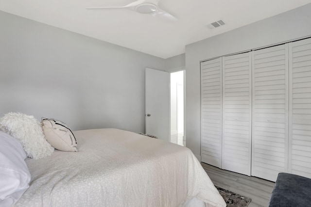 bedroom with light hardwood / wood-style floors, a closet, and ceiling fan