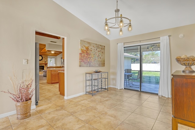 empty room with light tile patterned floors, an inviting chandelier, a large fireplace, vaulted ceiling, and baseboards