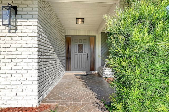 entrance to property featuring brick siding