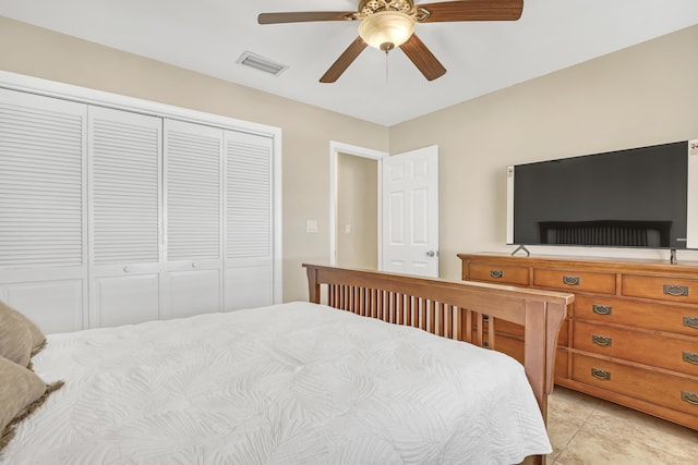 bedroom featuring a closet, light tile patterned flooring, visible vents, and a ceiling fan