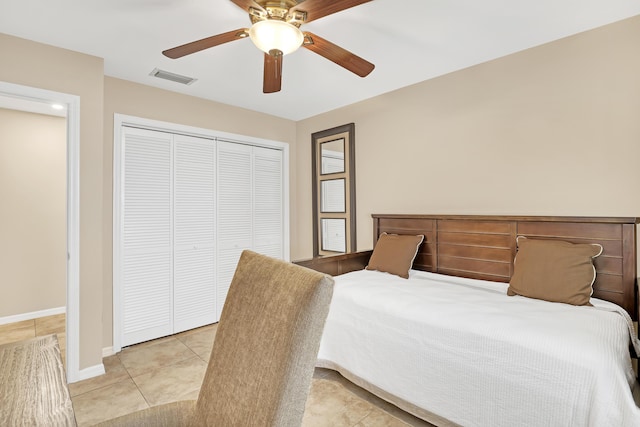 bedroom featuring light tile patterned floors, ceiling fan, visible vents, baseboards, and a closet