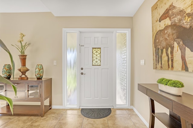 foyer entrance featuring baseboards and light tile patterned flooring