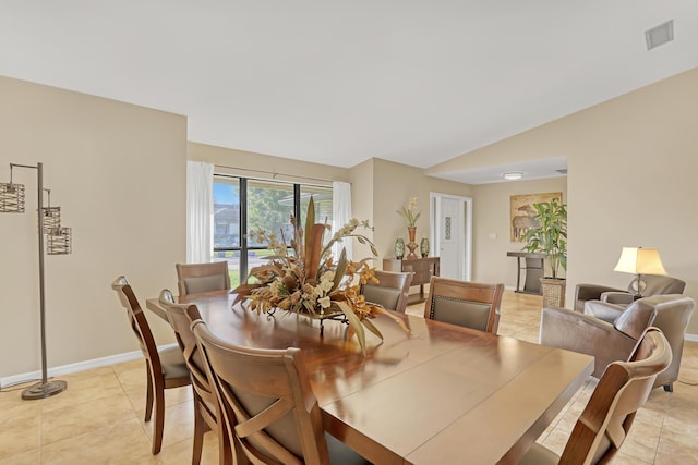 dining room featuring light tile patterned floors, baseboards, visible vents, and vaulted ceiling