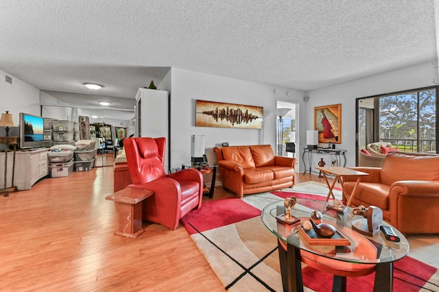 living room with a textured ceiling and light wood-type flooring