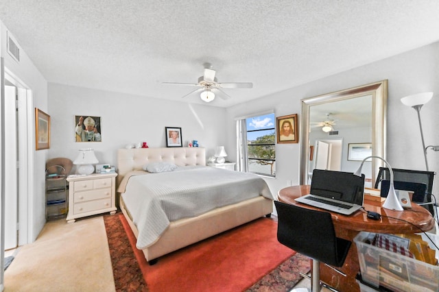 bedroom featuring ceiling fan, light colored carpet, and a textured ceiling