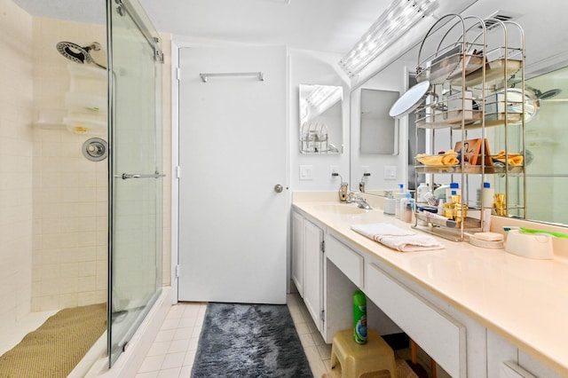 bathroom featuring tile patterned flooring, vanity, and a shower with door