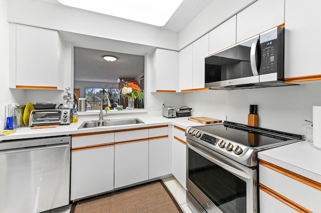 kitchen featuring stainless steel appliances, sink, and white cabinets