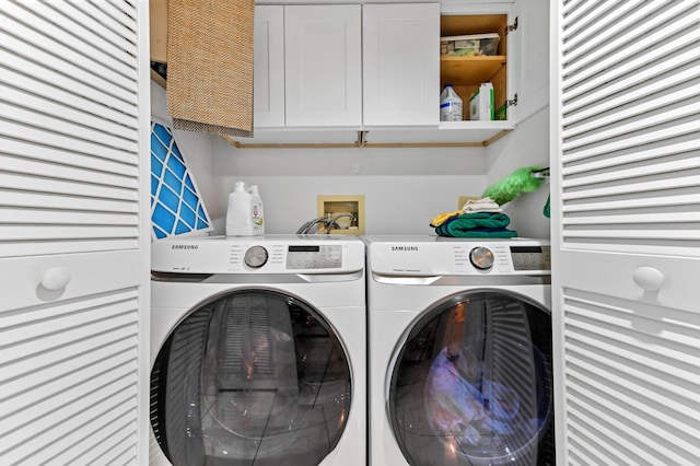 laundry room with cabinets and washer and clothes dryer