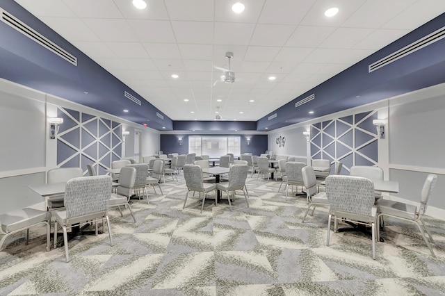 dining area with carpet and a paneled ceiling