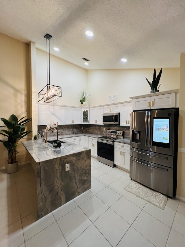 kitchen featuring appliances with stainless steel finishes, decorative light fixtures, sink, and white cabinets